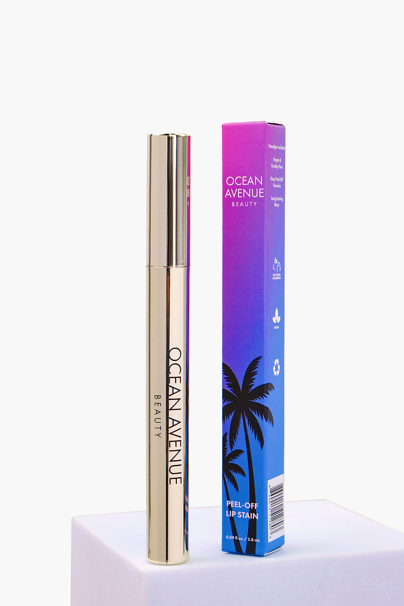 Café Cubano peel-off lip stain—tube and retail box on a pedestal, Ocean Avenue Beauty.