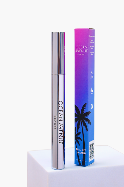 South Beach Squeeze peel-off lip stain—tube and retail box on a pedestal, Ocean Avenue Beauty.